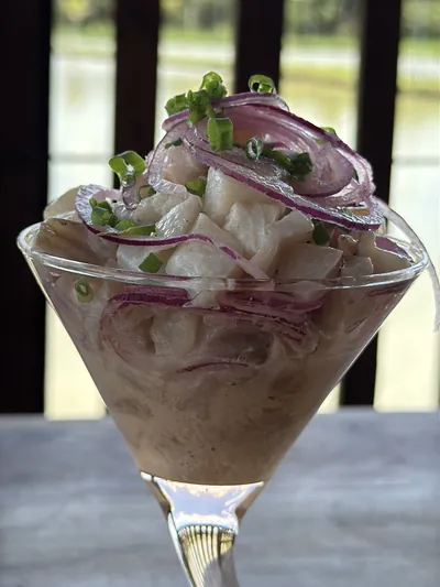 Ceviche de tilápia com cebola roxa servido na taça